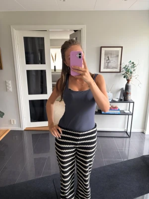 Mörkblå enkel body - Säljer en mörkblå body med breda axelband och rundad urringning. Toppen har en slim passform och är tillverkad i ett mjukt, stretchigt material som sitter skönt mot kroppen. Perfekt att matcha med mönstrade byxor eller kjol.