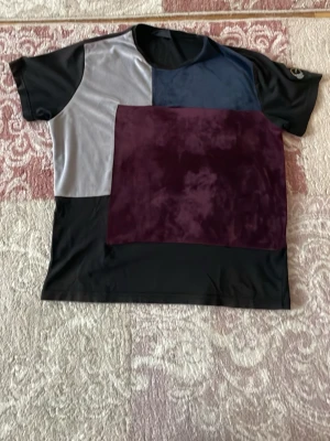 Patchwork t-shirt från La Vichy - Unik patchwork t-shirt från La Vichy med korta ärmar. T-shirten har block i svart, grått, marinblått och vinrött, vilket ger en cool och modern look. Tillverkad i mjuk polyester som känns skön mot huden. Perfekt för dig som vill sticka ut lite extra. Size: medium material : polyester. Bomull 
