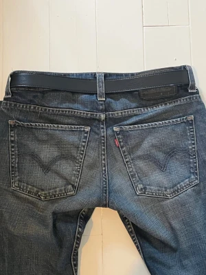 Vintage Levis faded jeans - Säljer mina vintage mörkbå jeans, Levi's 511 vintage. Raka ben och riktigt snygg och trendig tvätt. Jeansen har två bakfickor med det ikoniska v-märket. Perfekta för en avslappnad och cool stil!