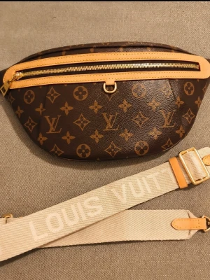 🤎 High Rise Monogram Belt Bag 🤎 - A modern classic featuring iconic monogram canvas, natural leather details, gold-tone hardware, and an adjustable jacquard strap with room for your phone, wallet, keys, sunglasses, and other daily essentials.  Wear it crossbody, on the shoulder, or around the waist.  ✨ Monogram canvas ✨ Natural leather trim ✨ Gold-tone hardware ✨ Adjustable strap included ✨ Spacious zip-top compartment One of the most popular luxury-inspired belt bag silhouettes  📦 Adjustable strap included 