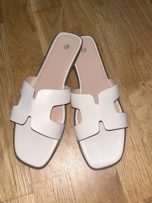 Vita slip-in sandaler med fyrkantig tå - erfekt för sommardagar. Storlek 38.