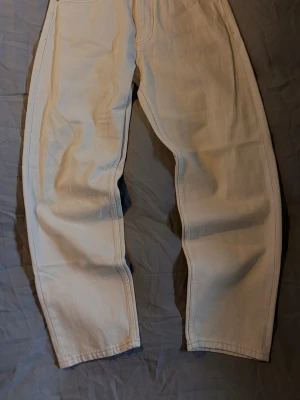 Vida beige jeans från Bershka - Säljer ett par beige '90s wide jeans från Bershka. De har hög midja, raka och vida ben samt klassiska fem fickor. Jeansen är tillverkade i denim och har bälteshällor och knappgylf. Perfekta för en avslappnad och trendig look.