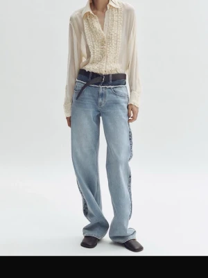 Ljusblå vida jeans med kontrastsömmar - Säljer ett par ljusblå jeans med bred passform och raka ben. Jeansen har coola kontrastsömmar i mörkare denim längs sidorna och klassisk femficksdesign. Perfekta för dig som gillar en avslappnad och trendig stil. Materialet är 100% bomull.