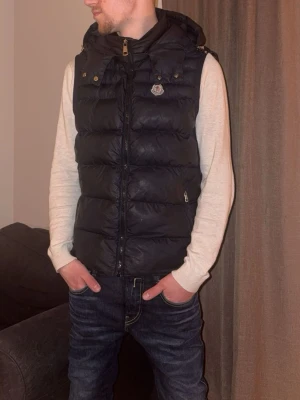 Äkta Moncler väst - Säljer nu min moncler väst då jag har många västar och cardigans. Det är en Moncler väst från 2019 som är i bra skick för att vara så gammal, men absolut man ser att den är använd. QR kod vid DIST lapp fungerar, har haft den inne på kemtvätt. 2400kr eller prisförslag. mvh Filip