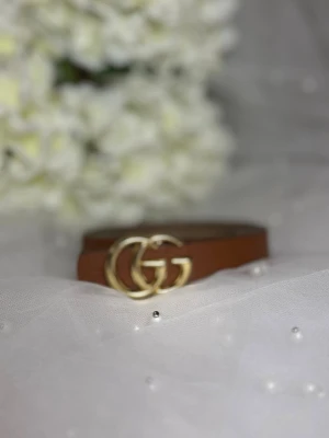 Brunt skärp  - . Bältet är gjort i skinn och har en klassisk, stilren design som passar till jeans eller kjol.