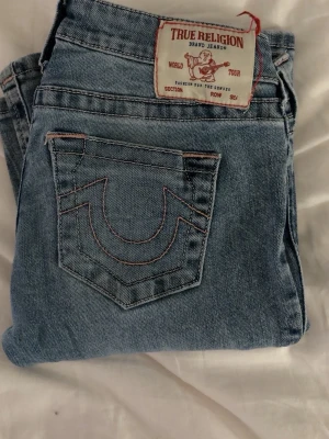 True religion jeans - As snygga true religion, bootcut jeans som Tyvvär blivit för små. Välanvända men fortfarande i bra skick💕 Hålen på insidan är från ett skosnöre som förut suttit runt midjan för att kunna justera midjans storlek, men är inte synliga och påverkar ingenting! Original pris: 1400kr