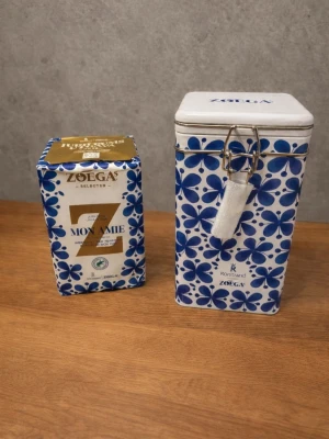 Zoégas Mon Amie kaffeburk & kaffe - Säljer en snygg kaffeburk i metall från Zoégas i samarbete med Rörstrand, dekorerad med blått Mon Amie-mönster och vit bakgrund. Medföljer ett Zoégas Mon Amie kaffe i matchande förpackning. Perfekt för dig som gillar design och kaffe.