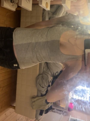 Grå ribbad linnetopp - Snygg grå ribbad linnetopp med breda axelband och rundad halsringning. Perfekt att styla med jeans eller kjol för en enkel och trendig look. Mjuk och stretchig känsla som sitter skönt på kroppen.