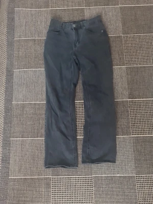 Mörkblå raka jeans - Snygga mörkblå jeans med rak passform och klassisk femficksdesign. Jeansen har hög midja och stängs med knapp och dragkedja. Perfekta för en avslappnad och stilren look.