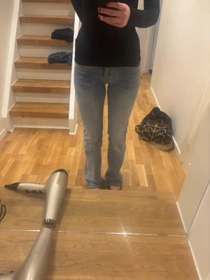 Ljusblå bootcut jeans från madlady - Säljer ett par ljusblå mid waist bootcut jeans. Jeansen har en snygg tvättad look och är tillverkade i denim med lite stretch för skön passform. Byxorna är från madlady i storlek 38 och längd extra tall.  De är använda typ 2 gånger och är i väldigt bra skick. Skriv för mer bilder!!