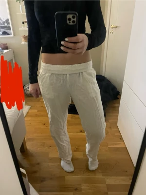 Vita linnebyxor från Lindex - Säljer ett par knappt använda vita linnebyxor från Lindex med resår i midjan. Byxorna är luftiga och har en avslappnad passform, perfekta för en bara dag eller bara chill . Materialet är linneblandning som känns svalt och skönt. 