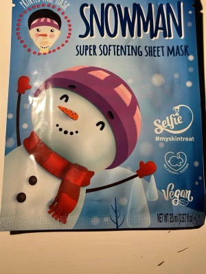 Snowman super softening sheet mask - En rolig och mjukgörande sheet mask med snögubbe-motiv från Selfie. Masken är vegansk och ej testad på djur, perfekt för att ge huden extra fukt och mjukhet. Kommer i en blå förpackning med snögubbe i lila mössa och röd halsduk.