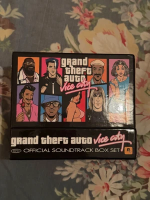 Grand Theft Auto Vice City Soundtrack - Grand Theft Auto Vice City Official Soundtrack Box Set med 7 CD-skivor. Varje CD innehåller musik från en radiostation i spelet med DJ-dialog. Jätte sällsynt. Perfekt för fans av GTA och retrospel.