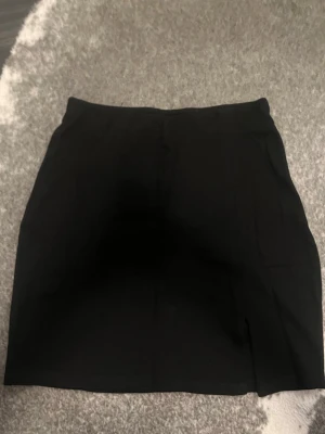 Svart kortkjol med slits - En stilren svart kortkjol med slits prislappen är avklippt men en liten bit är kvar och det är från ginatricot dam❤️