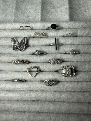 Snygga silvriga ringar med olika motiv - Supersnygga silverringar i nytt skick alla utom den som tappat en liten sten. Köper man 2 st får man en slumpmässig på köpet!! Skriv för flera frågor osv!! 39kr/st🩷🩷 