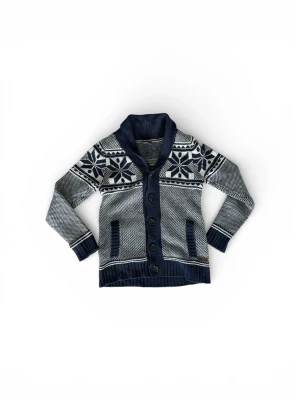 Cardigan  - Snygg mörkblå och vit stickad kofta med stora snöstjärnemönster över bröstet och axlarna. Koftan har bred sjalkrage, knappar framtill och två fickor. Ribbstickade muddar och nederkant ger extra stilpoäng. Perfekt för kalla dagar.