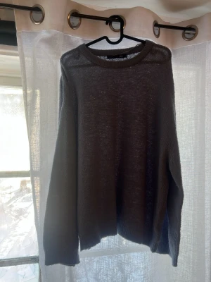 Ljusblå stickad tröja - En enkel och stilren stickad tröja med rund halsringning och långa ärmar. Tröjan har ribbade muddar vid ärmslut och nederkant samt knappdetaljer på axlarna. Perfekt för lager på lager och passar till det mesta.