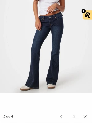 True Religion mörkblå bootcut jeans - kolla sista bilden, Slitningar från att ja råkat gå på dom därav priset. Säljer ett par mörkblå bootcut jeans från True Religion med ikoniska kontrastsömmar och stora fickor bak med lock och metallknappar. Klassisk femficksmodell i stretchigt denimtyg som sitter snyggt och ger en retrovibe.