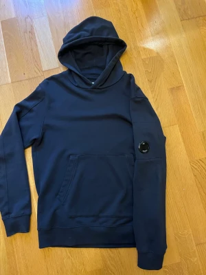 Cp company hoodie  - Den är så gott som ny och har inga synliga defekter. Den är i junior storlek men skulle säga att den sitter som S/M vuxen. Pris går alltid att diskutera! 