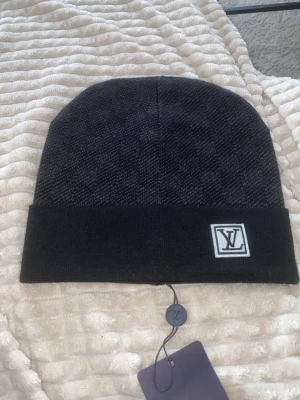 Svart rutig mössa - Snygg svart mössa med ett rutmönster.