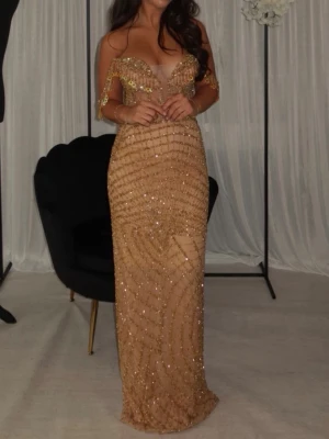 Glittrig guldig långklänning - Säljer min klänning från mina fashion, supersnygg och passar till både bröllop och balen. Har även korsett så man kan justera om man vill att klänningen ska sitta lite tajtare. 