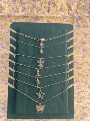 Söta silverfärgade halsband med hängen - Säljs ihop 130kr. Sex tunna silverfärgade halsband med olika hängen: hjärta, svamp, ängel, ängel, tingeling, stjärna och fjäril. Kedjorna är smala och har en minimalistisk stil. Perfekt för att mixa och matcha till olika outfits. Ej äkta, säljs 15kr st❤️ har fler och olika halsband. Kedja 56,5 cm lång. (Har gjort smyckena själv) 