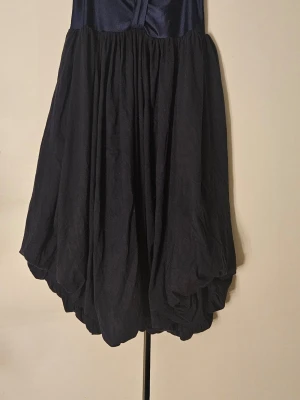 Mörkblå bandeauklänning - Unik mörkblå kortklänning med ballongformad kjol och slät överdel. Den har en bandeau överdel. Den är marineblå och övre delen är väldigt förlåtande mot svett fläckar. Så den är perfekt för sommarn.