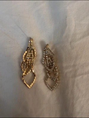 Guldig örhängen med stenar  - Snygga örhängen med genomskinliga stenar som dinglar . Perfekt accessoar för att lyfta din outfit med en tidlös och elegant touch. Passar dig som gillar stilrena smycken med en klassisk vibe.