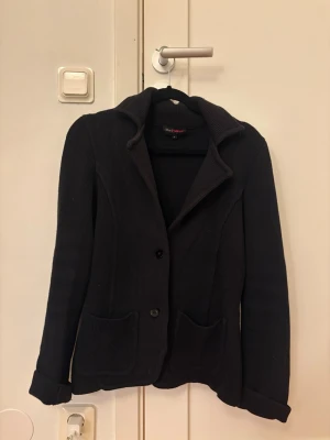 Svart stickad kavaj - Snygg svart stickad kavaj med två knappar framtill och två stora fickor. 