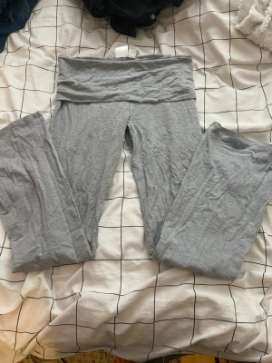 Grå mjuka leggings med låg midja - Säljer ett par grå leggings med låg midja och stretchigt material. De har en enkel design utan synliga loggor eller detaljer och är perfekta för en chill och avslappnad stil. Passar till oversized tröjor eller hoodies.
