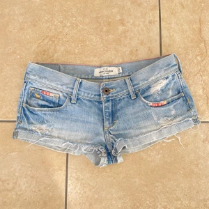 Lågmidjade jeansshorts - Säljer mina absoluta favorit lågmidjade jeans shorts från abercrombie and fitch som tyvärr har blivit för små för mig. De är i en jättefin ljusblå färg och perfekta till våren och sommaren.  Midjemåttet är 36 cm rakt över 💕