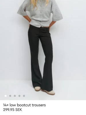 Svarta bootcut byxor low waist - Snygga svarta bootcut byxor med låg midja. Byxorna har en klassisk passform med utsvängda ben och är perfekta för en trendig look. Tillverkade i ett mjukt och bekvämt material som passar till många olika stilar.