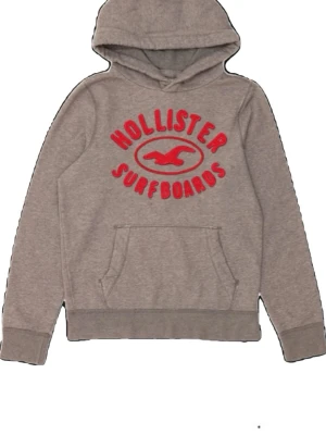 Grå Hollister hoodie med röd text - Snygg grå hoodie från Hollister med röd broderad text och logga på bröstet. Riktigt bra skick och passar mer S än M!