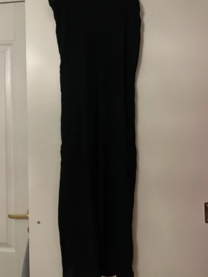 Svart lång klänning - En stilren svart långklänning med rak passform och ärmlös design. 