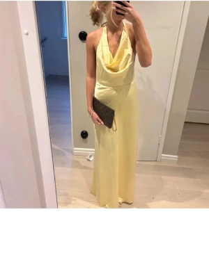 Balklänning  - Säljer min gula balklänning som endast är använd en gång, passar perfekt och sitter jätte bra. Öppen rygg och långa knytband. Materialet är nästan som siden/satin och mjukt
