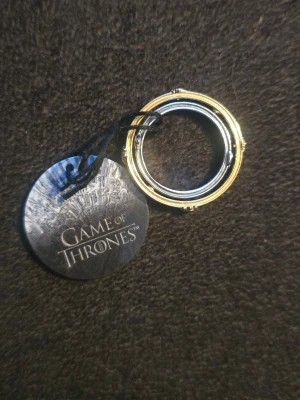 Game of Thrones ringar med stenar - Två ringar inspirerade av Game of Thrones, en i guld- och en i silverfärg med detaljerade mönster och en liten klar sten i mitten. 16,5 i storlek. Nyskick från Pandora. Nypris 999 kr