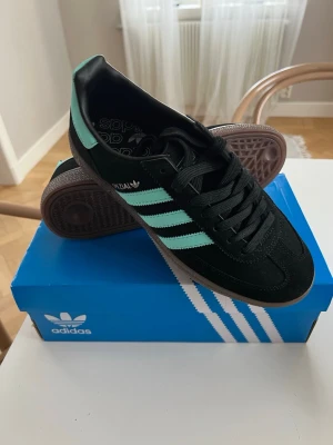 Adidas Spezial svarta sneakers - Snygga Adidas Spezial sneakers i svart mocka med mintgröna ränder och detaljer. Klassisk låg modell med gummisula och svart snörning. Perfekta för dig som gillar retrostil och streetwear. Nya, ångrade mej