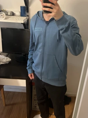 Blå Peak Performance zip hoodie - Snygg blå kofta från Peak Performance med dragkedja framtill och två stora fickor. Helt ny oanvänd!! 