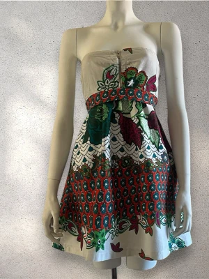 Strapless blommig kortklänning - Säljer en axelbandslös kortklänning med färgglatt blommönster i grönt, rött och vitt. Perfekt för sommarens alla tillfällen! #klänning