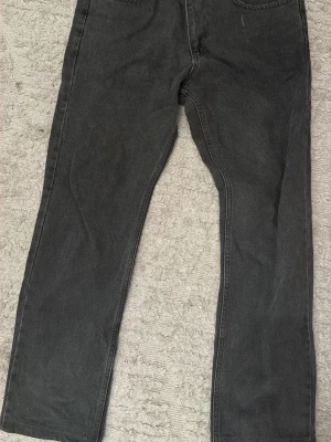 Levi's jeans 501 - Snygga svarta jeans från Levi's med rak passform och klassisk femficksdesign. Jeansen har en diskret tvättad look och är tillverkade i slitstark denim. Perfekta för en avslappnad och trendig stil. Skick 9/10 använda fåtal gånger forfarande i god skick. Storlek W31 L32