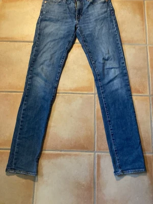 Blå raka jeans från Levi's - Ett par blå Levis jeans med en lite tvättad look, storleken är 30 34