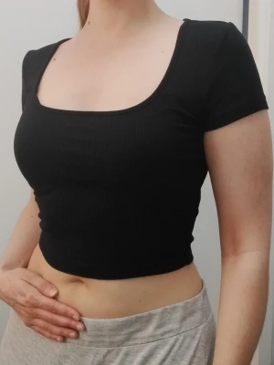 Svart smickrande ribbad topp  - Svart ribbad topp från i storlek S. Tillverkad av 93% viskos och 7% elastan vilket gör att det mjuka tyget andas i sommarvärmen. Perfekt basplagg att styla till olika outfits. Mycket smickrande. Kolla gärna mina andra annonser <3.