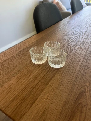 Tre små glasformar i pressglas - Säljer tre små runda glasformar i klart pressglas med dekorativt mönster. Perfekta till servering av såser, små snacks eller som ljushållare. Stilrena och passar till det mesta i köket eller på bordet.
