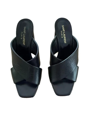 Svarta lädersandaler från Saint Laurent - Säljer ett par svarta sandaler från Saint Laurent med breda korsade remmar i läder och fyrkantig tå. Sandalerna har en hög blockklack och elegant design med logotyp på innersulan. Perfekta för dig som vill ha en stilren och lyxig look.