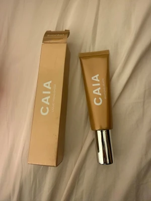CAIA Liquid Highlighter Bronzed Beach - Flytande highlighter från CAIA i nyansen Bronzed Beach. Kommer i en snygg guldig tub med silverfärgat lock och matchande förpackning. Perfekt för att ge huden en solkysst glow och highlighta ansiktets höga punkter. Använd en gång 