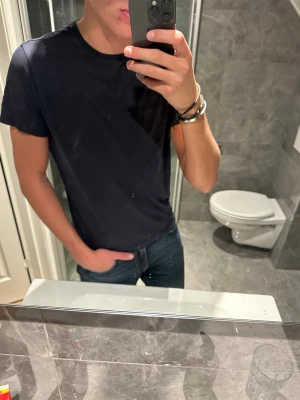 Mörkblå T-shirt Oscar Jacobsson  - En riktigt snygg mörkblå T-shirt från Oscar Jacobsson. En perfekt T-shirt som sitter grymt runt halsen. Passar perfekt nu till sommaren. Tyvärr är den ganska kort på mig och jag är 188cm. Rekommenderar en längd mellan 170-180 för optimal passform. Hör av er vid fler frågor :)