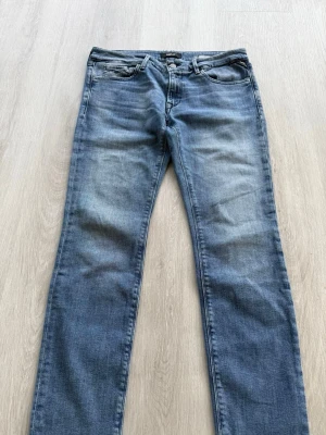 Replay jeans - Snygga blå jeans från Replay med klassisk femficksmodell och slitna detaljer på låren. Jeansen har normal midja, dragkedjegylf och är tillverkade i mjuk denim med lite stretch för extra komfort.