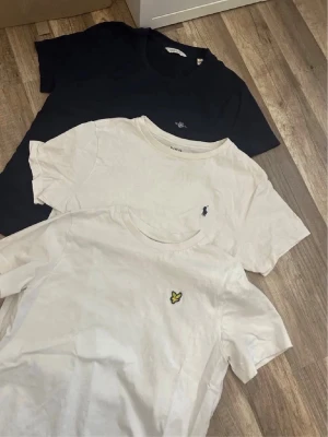 3 märkeskläder t Shirt - Säljer tre snygga t-shirts: en marinblå från gant, en vit från Ralph Lauren med broderad logga och en vit från Lyle & Scott med gul logga. Alla har klassisk passform, rund hals och korta ärmar. Perfekta basplagg till garderoben.alla är äkta från kidsbrandstore. Kom privat och diskutera pris!! De kostar inte 1kr. Går med på det mesta!