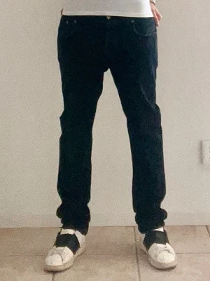 Nudie Jeans  - Ett par fina jeans från Nudie Jeans & Co! De är i ett bra skick förutom att de har slitningar på vissa ställen vilket jag själv tycker ger jeansen karaktär. De är i storlek W33 & L32 och i modellen Grim Tim!  Skriv om du har fler frågor eller om du är i behov av fler bilder, priset är inte hugget i sten och kan diskuteras!