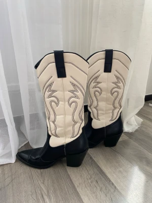 cowboy boots med brodyr - Snygga cowboy boots i svart och vitt med spetsig tå och bred klack. Storlek 37 men passar mig som är 38/39!🥰